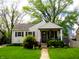 Inviting single story home featuring well-manicured lawn and charming covered front porch at 5441 E 17Th St, Indianapolis, IN 46218