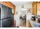 Galley kitchen with black appliances and an open view to the dining area at 5441 E 17Th St, Indianapolis, IN 46218