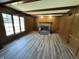 Cozy living room with wood paneling, a brick fireplace, and hardwood flooring at 4256 Bending Ln, Greenwood, IN 46143