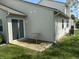A back patio with a small table next to a sliding glass door on a home with vinyl siding at 8520 Bison Woods Ct, Indianapolis, IN 46227