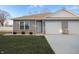 Gray siding two-car garage home with a landscaped lawn and white fence at 1501 Coen Ct, Columbus, IN 47201