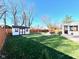 Spacious fenced backyard featuring a storage shed, hot tub, green grass, and mature trees at 562 Nelson Dr, Brownsburg, IN 46112