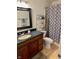 Bathroom featuring a shower with patterned curtain, a rack shelf, toilet, sink, mirror, and vanity at 562 Nelson Dr, Brownsburg, IN 46112