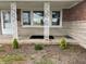 Charming front porch with decorative white posts, leading to the main entrance and landscaped garden at 11 S 1050 W, Jamestown, IN 46147