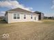 Spacious backyard features a simple patio area and rear view of the house with large windows at 132 Velvet Hat Rd, Danville, IN 46122
