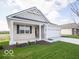 Inviting single-story home featuring a welcoming covered front porch and manicured lawn with shrubbery at 132 Velvet Hat Rd, Danville, IN 46122