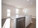 Bright kitchen island with stainless steel dishwasher, white cabinets, and views to the backyard at 132 Velvet Hat Rd, Danville, IN 46122