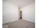 A well-lit bedroom with neutral walls and flooring, showcasing a door and ample space at 120 Velvet Hat Rd, Danville, IN 46122