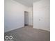 A carpeted bedroom with a closet and white paneled door at 120 Velvet Hat Rd, Danville, IN 46122