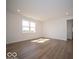Spacious living room featuring wood-look floors, recessed lighting, and large windows overlooking the front yard at 126 Velvet Hat Rd, Danville, IN 46122