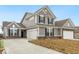 Charming two-story home with gray siding, black shutters, brick foundation, and three-car garage at 243 Hunters Ridge Dr, Danville, IN 46122