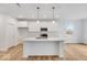 Well-lit kitchen featuring white cabinets, stainless steel appliances, marble countertops, and a central island at 243 Hunters Ridge Dr, Danville, IN 46122