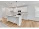 Modern kitchen features white cabinets, stainless steel appliances, and a central island with marble countertops at 243 Hunters Ridge Dr, Danville, IN 46122