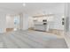 Bright open-concept living space showcases a modern kitchen with island, hardwood floors, and carpeted living room at 243 Hunters Ridge Dr, Danville, IN 46122