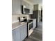 Updated kitchen with stainless steel oven, microwave, refrigerator, quartz counters, and gray cabinets at 7530 Redcliff Rd, Indianapolis, IN 46256