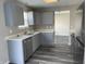 Updated kitchen featuring stainless steel appliances, gray cabinets, and luxury vinyl plank flooring at 7530 Redcliff Rd, Indianapolis, IN 46256