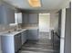 Updated kitchen featuring stainless steel appliances, gray cabinets, and luxury vinyl plank flooring at 7530 Redcliff Rd, Indianapolis, IN 46256