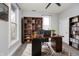 Well-lit home office featuring a spacious desk, bookshelves, and a comfortable chair at 1423 Hoyt Ave, Indianapolis, IN 46203