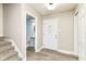 Bright foyer with a white front door, wood-look floors and stairs leading up to the next level, providing a welcoming entrance at 383 Carmelaire Ct, Carmel, IN 46032