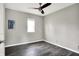 Cozy bedroom featuring gray walls, dark wood-look floors, ceiling fan and a window providing natural light at 8902 Carla Dr, Indianapolis, IN 46219