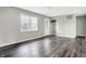 A large, open living room area with dark wood-look floors, neutral paint, and large window at 8902 Carla Dr, Indianapolis, IN 46219