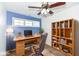 A cozy office with a large wooden desk, a bookshelf, and natural lighting at 11736 Grazing Ln, Indianapolis, IN 46239