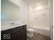Well-lit bathroom with a dark wood vanity, a shower-tub combo, and sleek wood-look flooring at 6322 Granby Dr, Whitestown, IN 46075