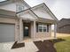 Inviting entryway to a single-Gathering home featuring a covered porch, a dark front door and manicured landscaping at 6322 Granby Dr, Whitestown, IN 46075