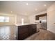 Open kitchen with stainless steel appliances, island with sink, dark cabinets and view to living area at 6322 Granby Dr, Whitestown, IN 46075
