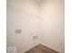 An empty laundry room with wood-look vinyl flooring and a wire rack shelf, ready for a washer and dryer at 6322 Granby Dr, Whitestown, IN 46075