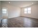 Open-concept living room with wood-look floors and lots of natural light at 6322 Granby Dr, Whitestown, IN 46075