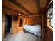 Cozy log cabin bedroom with wood paneled walls, exposed beams, and a comfortable bed at 1155 Cope Rd, Martinsville, IN 46151