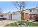Two car garage with a concrete driveway, and a newly planted tree in the front yard at 5527 Vin Rose Ln, Lawrence, IN 46226