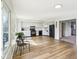 Open kitchen with black appliances, light cabinets, wood flooring and a sunlit eating area at 5527 Vin Rose Ln, Lawrence, IN 46226