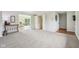 Bright living room with neutral carpet, white trim, and access to the sunroom at 5527 Vin Rose Ln, Lawrence, IN 46226