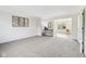 Open-concept living room featuring neutral carpeting and a sunroom at 5527 Vin Rose Ln, Lawrence, IN 46226