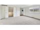 Spacious living room featuring neutral carpeting, a large window, and a white front door at 5527 Vin Rose Ln, Lawrence, IN 46226
