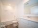 Clean bathroom with a tub, a white vanity with a modern faucet, and a large mirror at 6623 Sulgrove Pl, Indianapolis, IN 46221