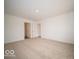 A large bedroom with neutral carpet with two open doors to the closet and bathroom at 6623 Sulgrove Pl, Indianapolis, IN 46221