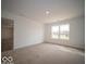 Bedroom featuring neutral carpet, an open entranceway and a large window with a view at 6623 Sulgrove Pl, Indianapolis, IN 46221