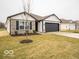 Inviting single-story home with a dark gray garage door and a freshly landscaped front yard at 6623 Sulgrove Pl, Indianapolis, IN 46221