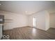 Living room space with a door leading outside, wood floors, and an open entrance into the kitchen at 6623 Sulgrove Pl, Indianapolis, IN 46221