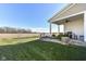 Covered patio and landscaped backyard with a view of open fields at 12535 Tidecrest Dr, Fishers, IN 46037