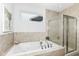 Relaxing bathroom featuring a soaking tub, shower, and stylish tile at 12535 Tidecrest Dr, Fishers, IN 46037