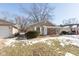 Tan house with brick accents, partially snow covered lawn, and a partially visible driveway at 3359 Laurel St, Indianapolis, IN 46227