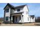 New construction home with white and gray siding, black framed windows, and a brick foundation against a blue sky at 16525 Iron Tree Ct, Westfield, IN 46074