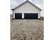 Two-car garage with black doors and white siding sits on a gravel driveway at 16525 Iron Tree Ct, Westfield, IN 46074