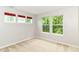 Comfortable bedroom featuring neutral carpet, three windows, and red window treatments at 5171 Alpine Violet Way, Indianapolis, IN 46254