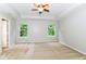Bright bedroom features a tray ceiling, ceiling fan, and two windows with leafy views at 5171 Alpine Violet Way, Indianapolis, IN 46254