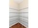 A walk-in closet featuring multiple metal shelving racks and wood flooring at 5171 Alpine Violet Way, Indianapolis, IN 46254